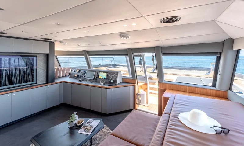 Hani I: Forward saloon with helm console, panoramic sea windows and lounge cushion with sun hat
