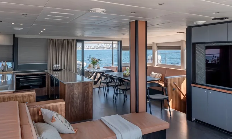 Hani I: Saloon sofa looking toward kitchen island and dining table with sea views