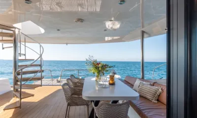 Hani I: Covered aft deck dining table with flowers, spiral stairs and sea view