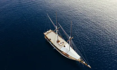 Senja: きらめく濃い青の海に浮かぶ2本マストのセーリングヨットを上空から見た様子