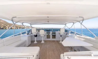 My Lady Alaska: Flybridge sombreado com assentos brancos, mesa e cadeiras de comando voltadas para o mar