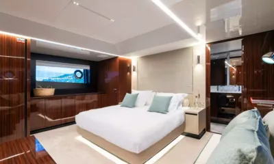 L'as Bleu: Cabin with double bed, glossy wood cabinetry, wide hull window and ensuite doorway