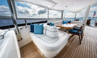 Southern Belle: Zona salotto sul ponte superiore con cuscini blu e tavolo in legno sotto un tendalino