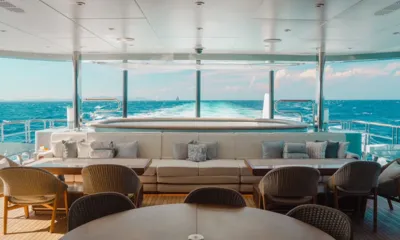After you: Convés de popa coberto com mesa redonda, cadeiras de vime e sofá voltados para um jacuzzi e a esteira no mar