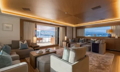 Alfa: Lounge com iluminação aconchegante, sofás cinza e portas abertas para um deck externo