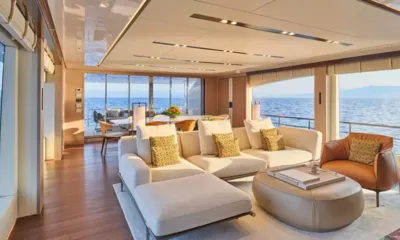 Four Joys: Salão claro com sofás creme, almofadas amarelas e vista para o mar, área de jantar ao fundo
