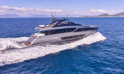 Menangio X: Iate a motor prateado navegando em mar azul, com colinas e nuvens ao fundo