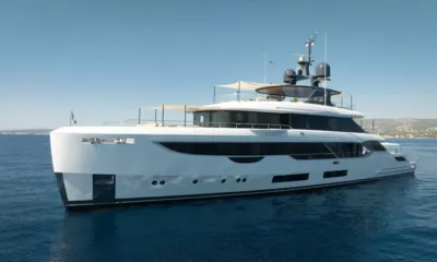 How Much is Enough: Iate a motor branco ancorado em águas azuis calmas com decks superiores sombreados