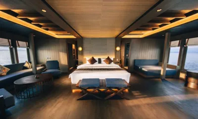 Bhavana: Cabina spaziosa con letto matrimoniale centrale, divani blu e finestre su entrambi i lati