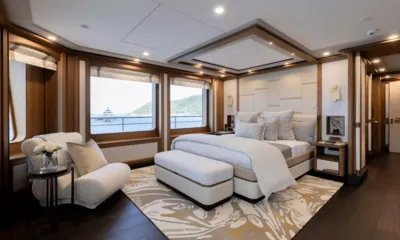Q: Cabine ampla com cama de casal, poltrona, tapete estampado e janelas para uma baía