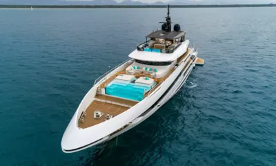 Maverick II: Iate ancorado visto de cima da proa, com piscina de laterais de vidro no convés de proa e lounges