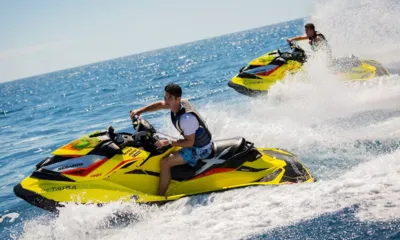 Taiba: 黄色いジェットスキーに乗った2人のライダーが水しぶきを上げて海上を疾走する