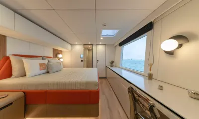Belldia: Cabina con letto matrimoniale con struttura arancione, grande finestra vista mare e lunga scrivania toeletta