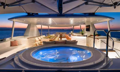 Santosha: Jacuzzi iluminado ao entardecer em frente a um bar e a uma mesa de jantar no deck superior