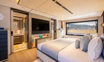 Sui Generis: Camarote con cama doble, televisor de pared y puerta abierta a un baño privado