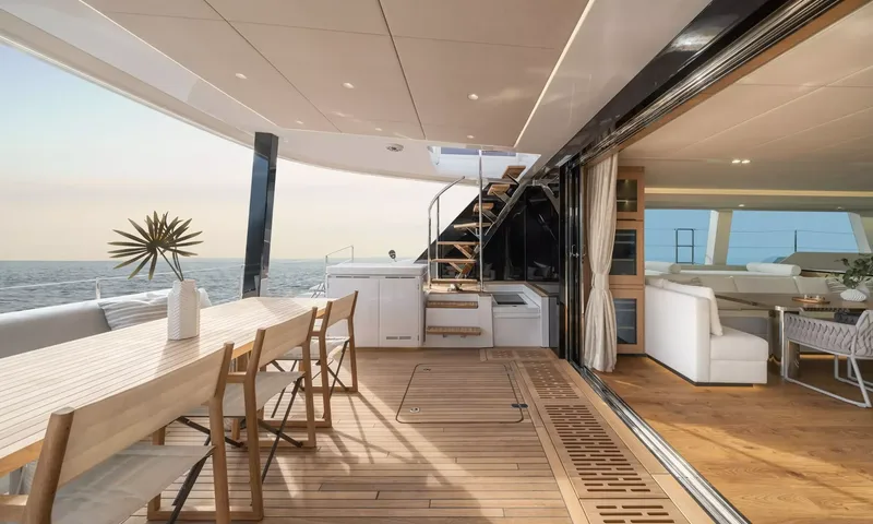 Ankawer VI: Aft cockpit dining table beside sliding glass doors opening into the saloon