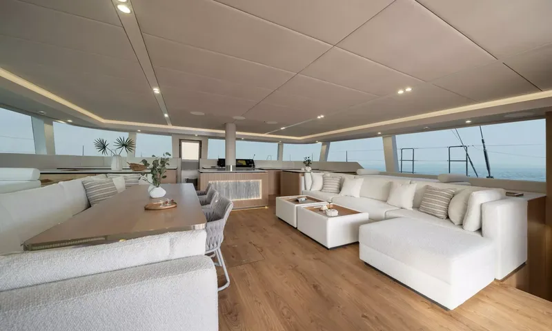 Ankawer VI: Spacious saloon with white sectional sofa, dining table and wraparound windows