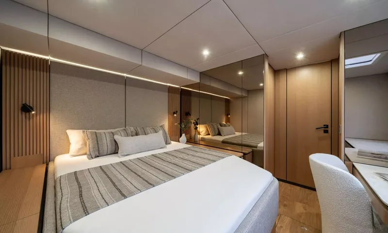 Ankawer VI: Double bed with striped throw, wood slat headboard lights and mirrored wardrobe