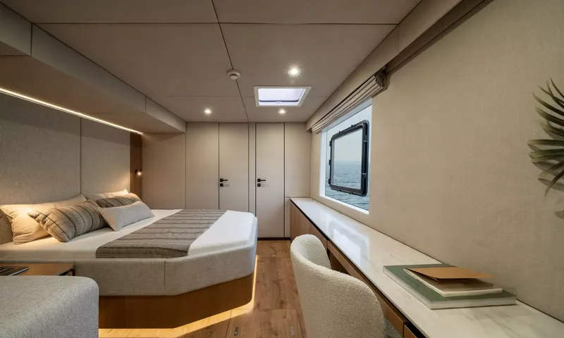 Ankawer VI: Cabin with double bed, long desk and hull window overlooking the sea