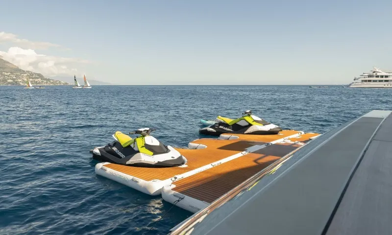 Seawolf X: Two personal watercraft on a floating dock beside the yacht at sea