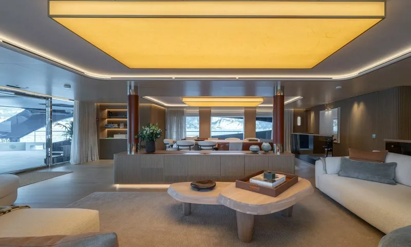 Seawolf X: Saloon with sofas and wooden coffee table, dining area beyond