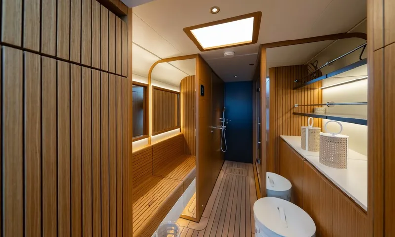 Seawolf X: Wood panelled spa area with bench, shower and shelves with baskets