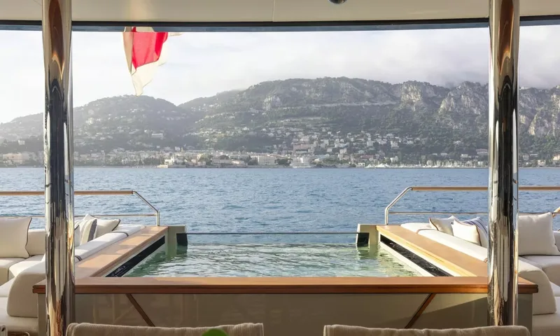 Seawolf X: Deck pool flanked by sofas looking out to sea and a hillside town