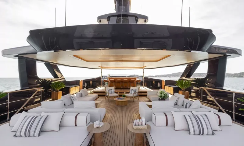 Seawolf X: Open deck with white sofas, striped cushions, potted plants and a bar under a dark overhang