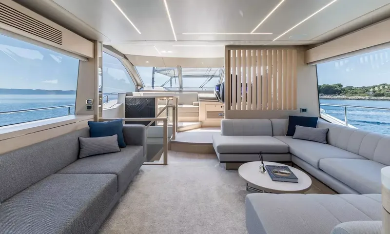 Ascend: Saloon lounge with grey sofas and large windows looking forward toward the helm
