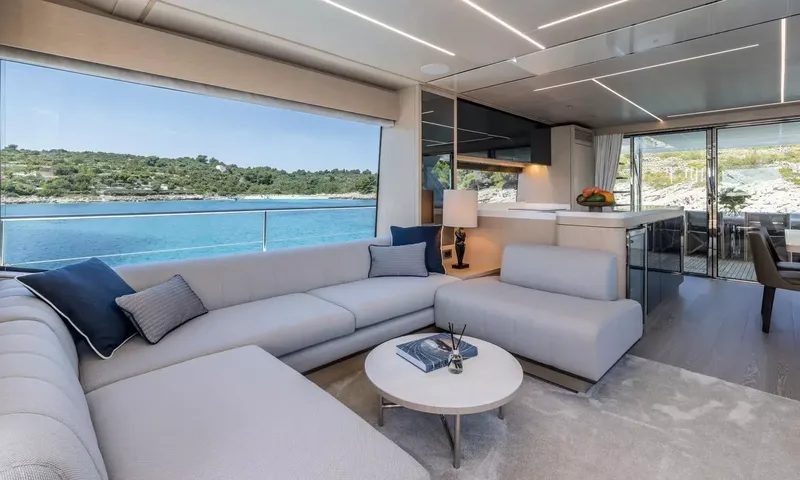 Ascend: Corner sofa beside a large window overlooking a calm bay