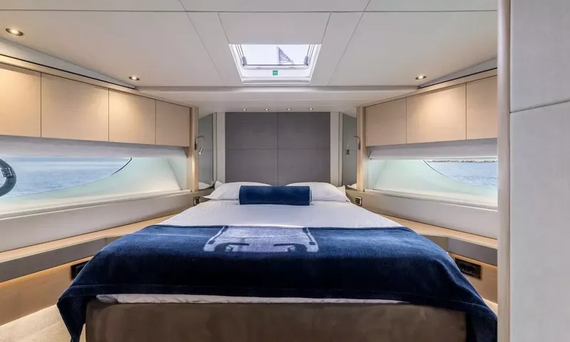 Ascend: Cabin with double bed, navy throw, overhead hatch and hull windows on both sides