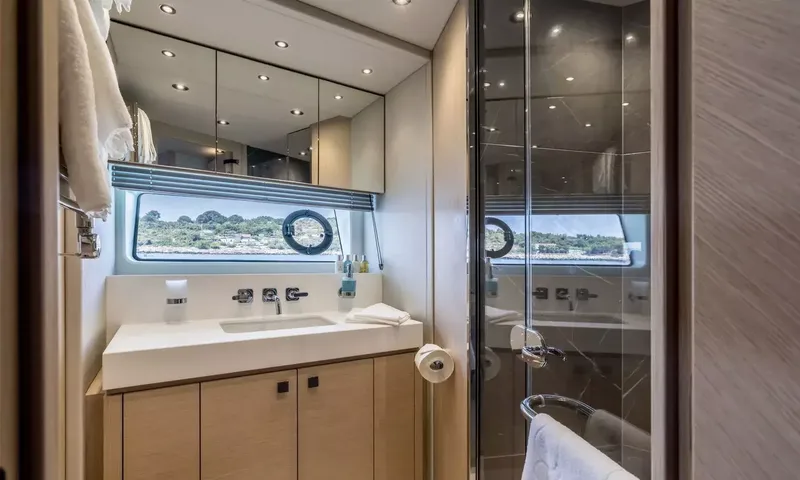 Ascend: Ensuite with wooden vanity, white basin, glass shower and porthole window