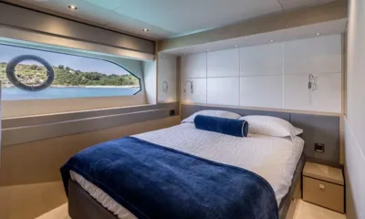Ascend: Double cabin with navy throw, reading lights and a window onto the shore