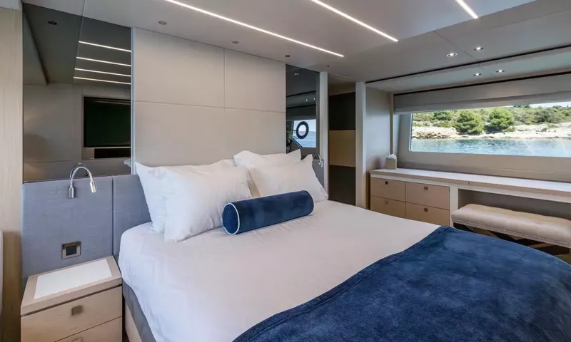 Ascend: Double cabin with white pillows, navy throw and dresser under a long window