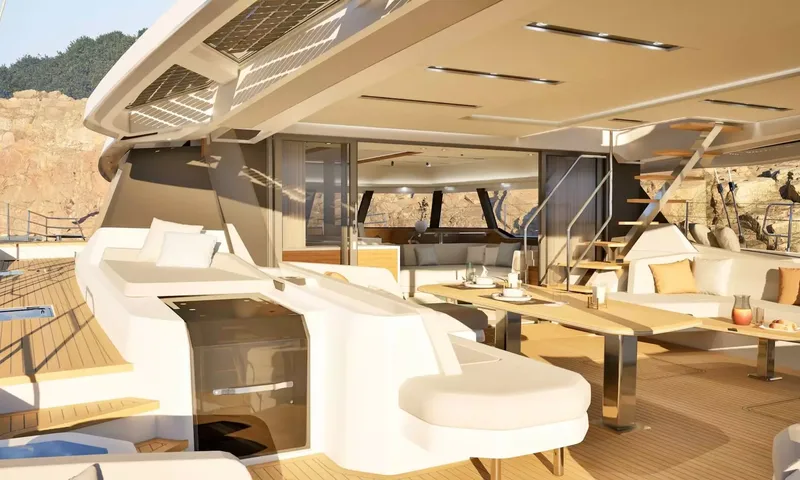 Elly II: Covered aft deck with dining table, sofas and stairs up to the flybridge