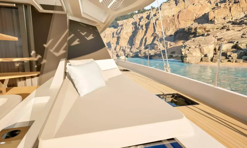 Elly II: Sunpad with pillow on the side deck facing a rocky cove