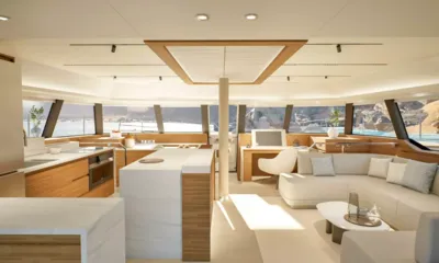 Elly II: Bright saloon with sofa, coffee table, desk and open kitchen, wraparound windows