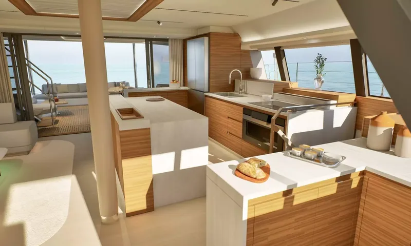 Elly II: Open galley with wood cabinets, island and sink, aft deck visible beyond
