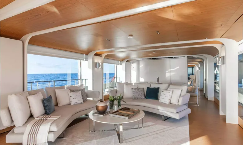 Angel: Bright saloon with curved cream sofas, round coffee table and large sea view windows