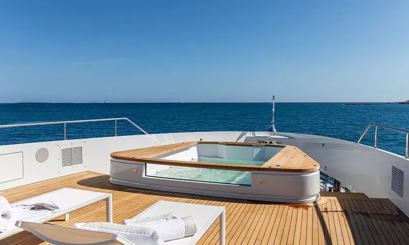 Angel: Foredeck jacuzzi with glass side and teak rim beside sun loungers facing the sea