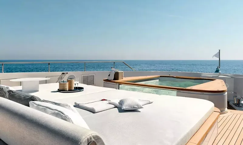 Angel: Large sunpad with towels and drinks tray beside a glass sided jacuzzi overlooking the sea