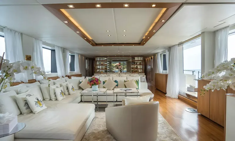 Kristo: Long bright lounge with white sofas, cushions, orchids and wooden floor
