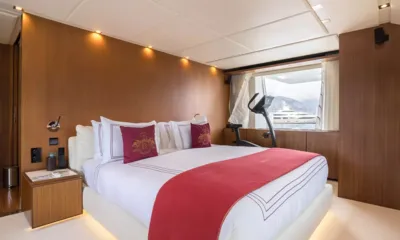 Kristo: Double cabin with red throw and cushions, wood panelling and an exercise bike by the window