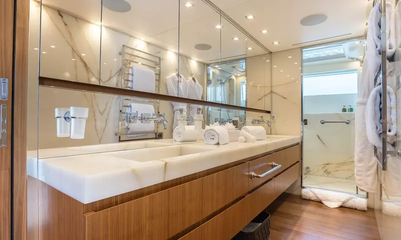 Kristo: Bathroom with long stone double basin, wooden vanity, mirrors and walk in shower