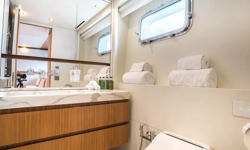 Kristo: Ensuite with marble basin, wooden vanity, rolled towels and porthole