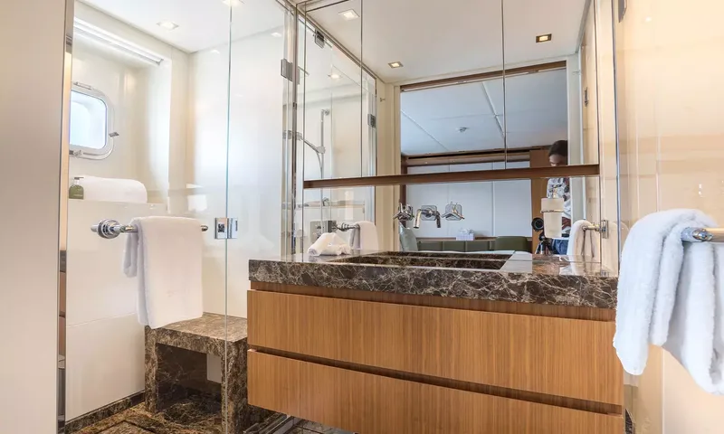 Kristo: Ensuite with dark marble basin, wooden vanity, glass shower and towels