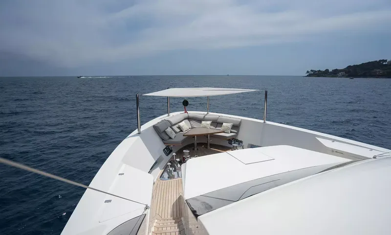 Kristo: Foredeck lounge with cushioned seating, a table and shade canopy facing open sea