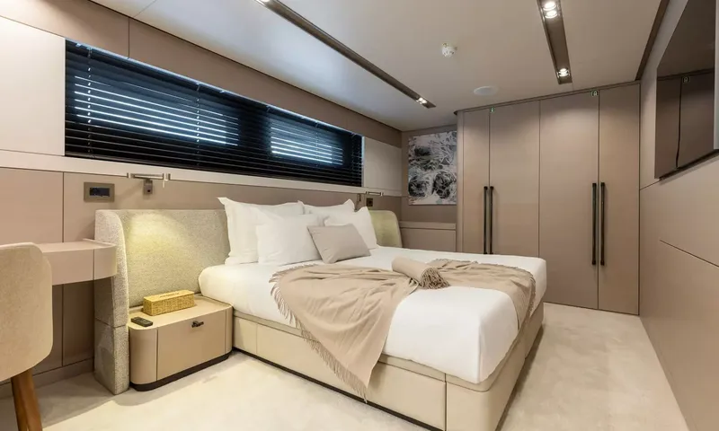 Oriy: Cabine com cama de casal, cabeceira estofada, guarda-roupas e janela com persianas