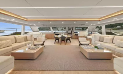 Amitatu: Wide bright saloon with cream sofas, coffee tables and a dining table beyond