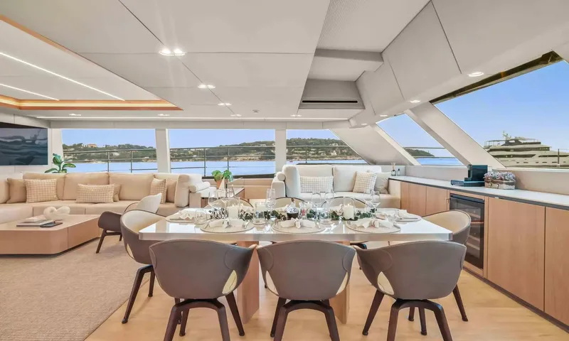 Amitatu: Set dining table for six inside the saloon with sea views through wide windows